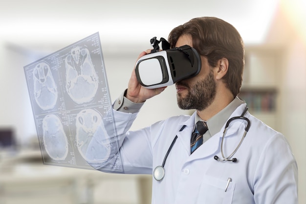 Medico maschio nel suo ufficio, utilizzando occhiali per realtà virtuale, guardando uno schermo virtuale