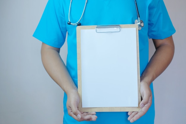 Male doctor holding blank clipboard