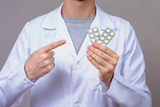 Male doctor holding pills