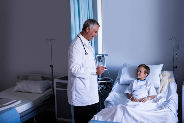 Male doctor interacting with patient during visit in ward