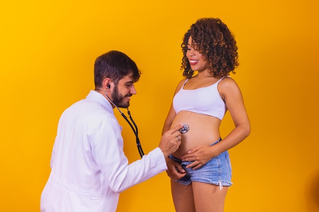 Male doctor is checking pregnant woman with stethoscope. Concept caring for pregnant woman