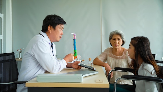 Male doctor is recommending an orthopedic treatment program for An elderly woman who brought her daughter to the hospital