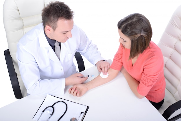 A male doctor in a lab coat checks a girl.