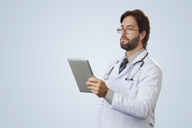 Male doctor  , looking at a tablet.