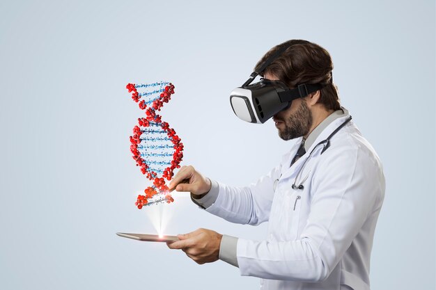 Medico maschio che esamina un dna virtuale che esce da un tablet su un muro grigio