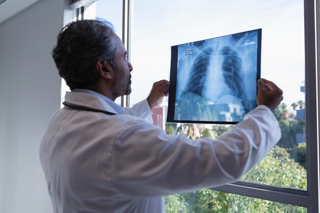 Male doctor looking at xray report in clinic at hospital