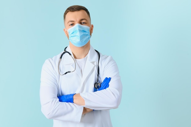 Male doctor in medical mask on color background