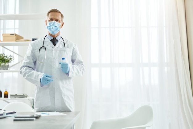 Photo male doctor in medical mask holding test tube