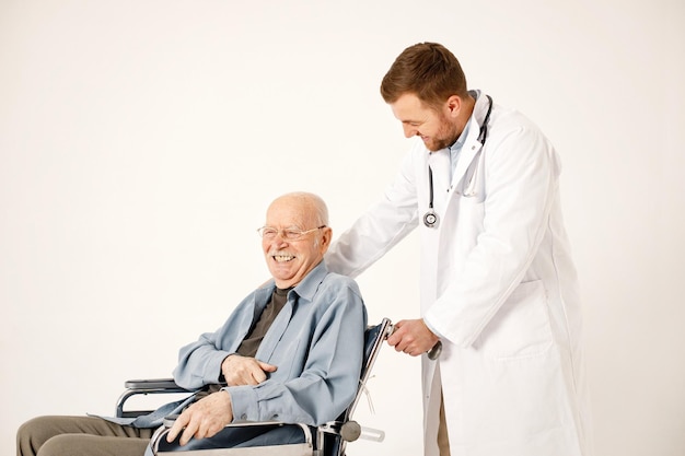 Male doctor and old man on a wheelchair isolated on a white background