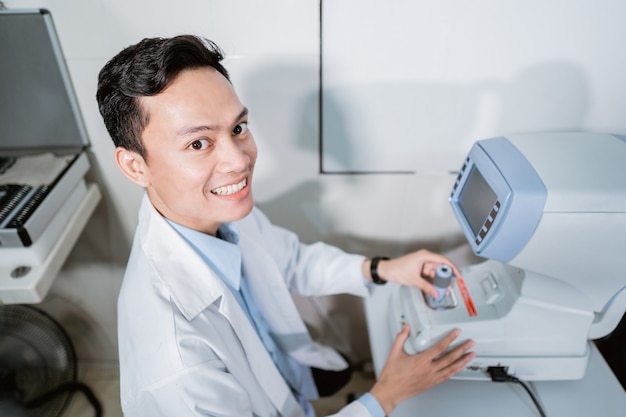 Un medico maschio che utilizza un computer oculistico in una stanza di una clinica oculistica