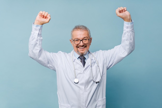 Medico maschio che alza le braccia nel concetto di vittoria di medicina e lotta contro la malattia