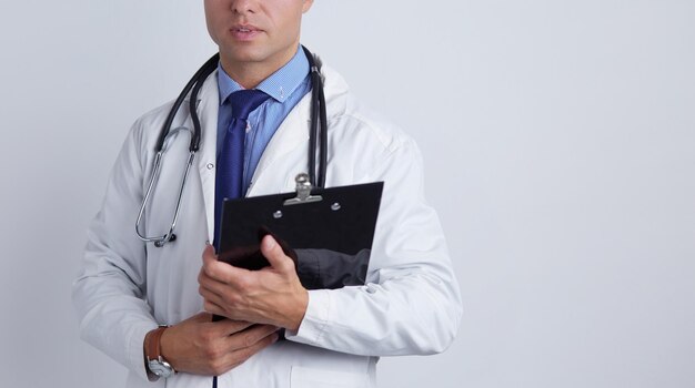 Фото Мужчина-врач, стоящий с папкой на белом фоне