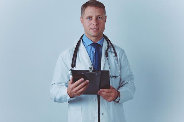 Male doctor standing with folder isolated on white background