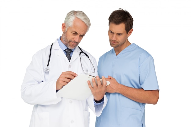 Male doctor and surgeon looking at reports