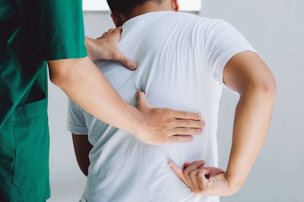 Male doctor therapist doing healing treatment on man's back.Back pain patient, treatment, medical doctor,massage for back pain relief office syndrome