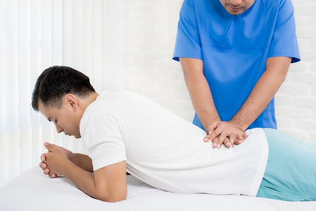Photo male doctor therapist treating lower back pain patient in clinic or hospital