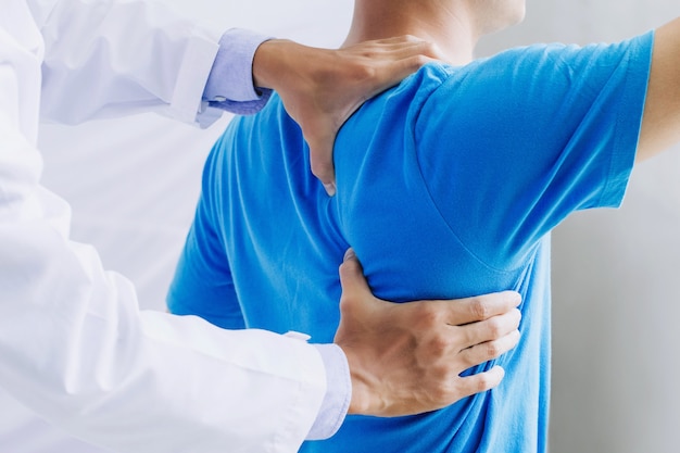 Male doctor therapist working examining treating injured back.Back pain patient, treatment, medical doctor,massage for back pain relief office syndrome.