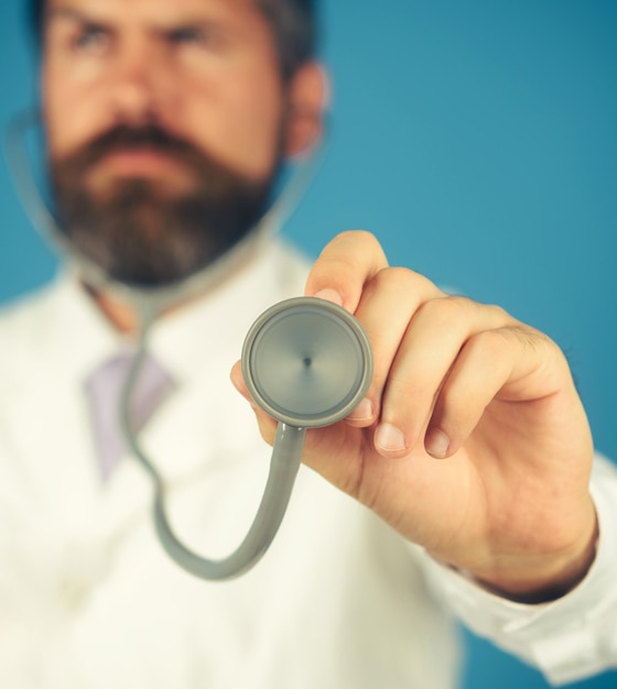 Male doctor in uniform with stethoscope in hand medical equipment healthcare and medicine concept