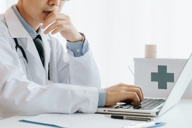 Male doctor use computer,research and analyze, Disease analysis ,and record patient information,