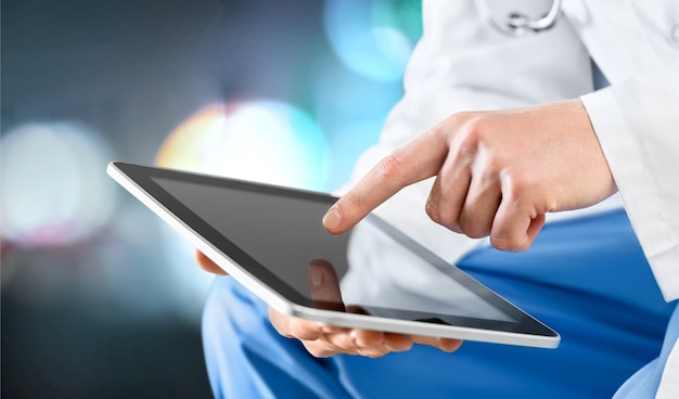 Male doctor using digital tablet, close up on hands