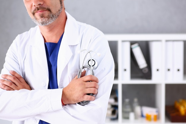 Male doctor with arms crossed on his chest in office