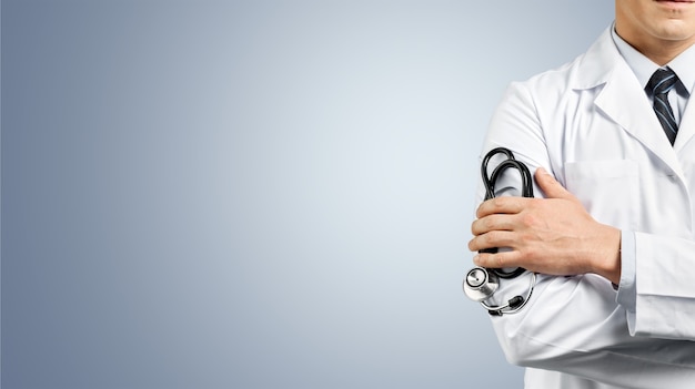 Male doctor with stethoscope on blurred hospital background