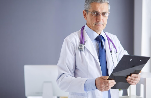 Male doctor writes notes on the clipboard in the hospital