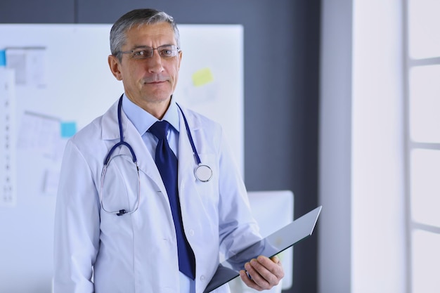 Male doctor writes notes on the clipboard in the hospital