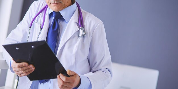 Male doctor writes notes on the clipboard in the hospital