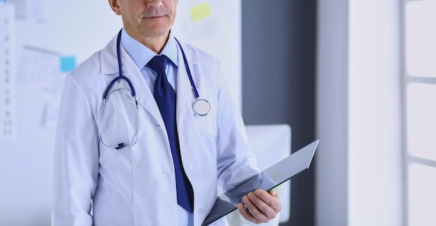 Male doctor writes notes on the clipboard in the hospital