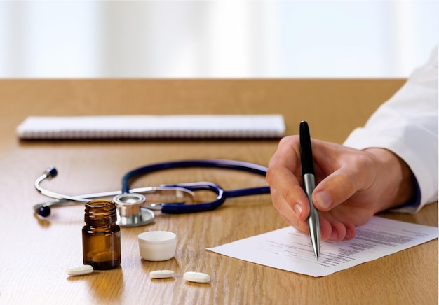 Medico maschio che scrive carta di prescrizione