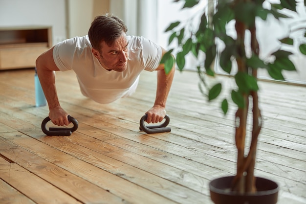 Male doing core training with equipment at home