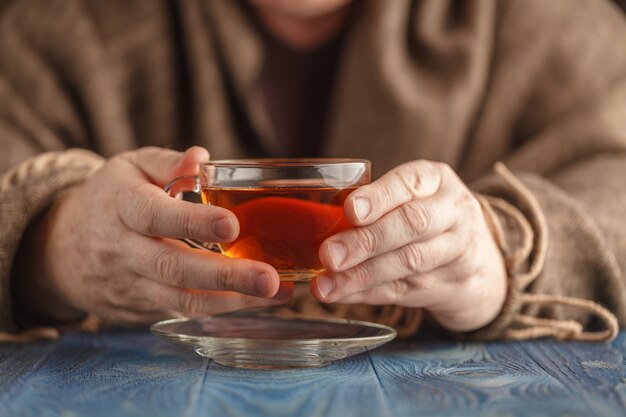 男性は寒い日に熱いお茶を飲む