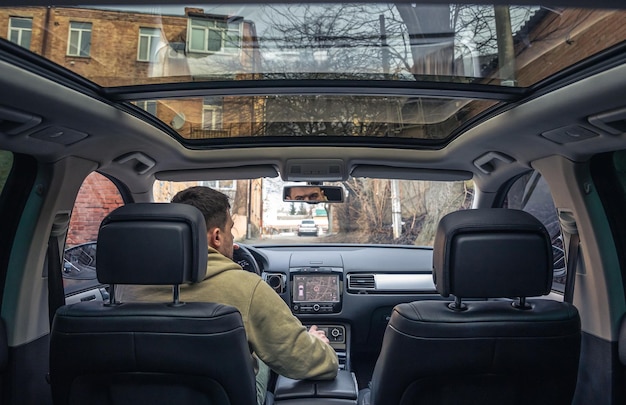 A male driver drives at speed through the streets of the city