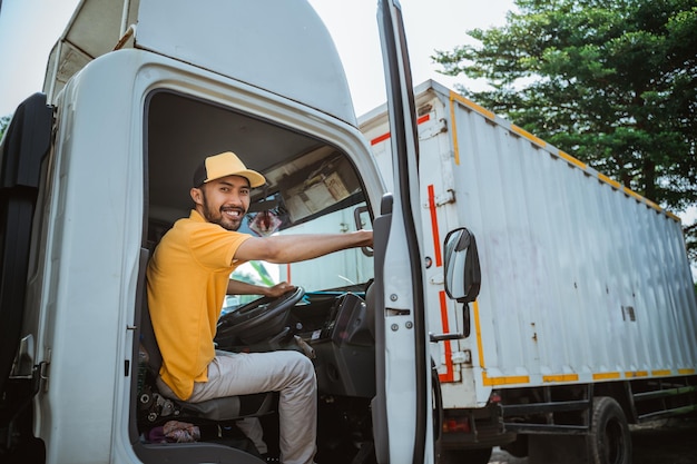 Male driver smiles as he closes the door of truck