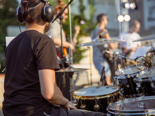 Male drummer having concert rehearsal on the street