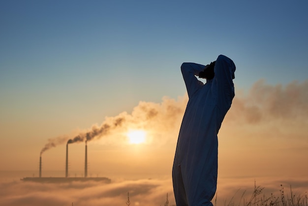 Male ecologist standing on territory of thermal power plant