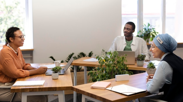 Foto impiegato maschio che conversa con i suoi nuovi colleghi al lavoro d'ufficio