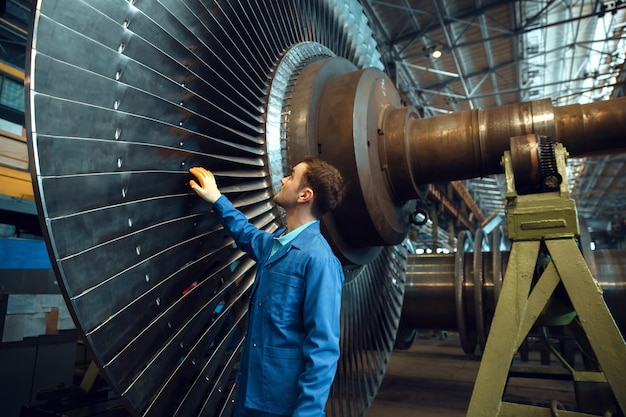 Male engineer checks turbine impeller vanes on factory