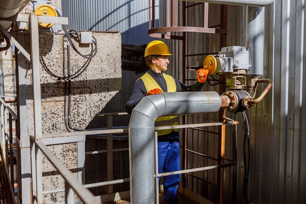 Male engineer in safety helmet working at factory