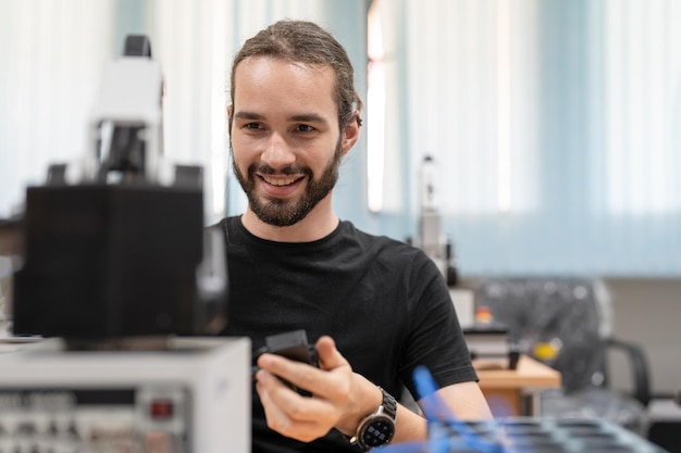 Foto progettazione di formazione per ingegneri maschili e modello di braccio robotico ai programmabile nella sala del laboratorio robotico dell'accademia