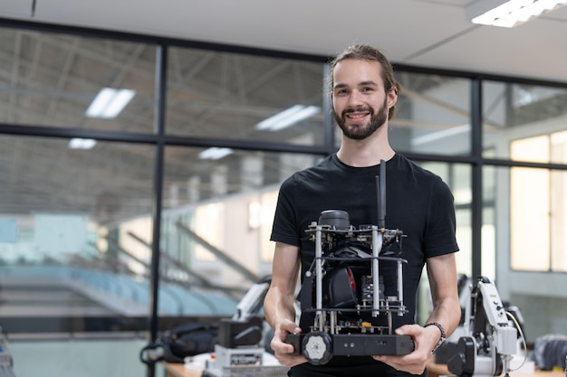 Foto progettazione di formazione per ingegneri maschi e modello di braccio robotico ai programmabile nella sala di laboratorio robotica dell'accademia