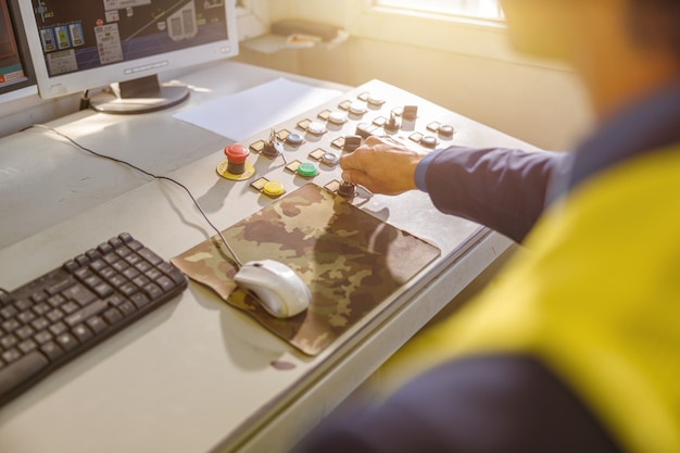 Male engineer using control panel at factory