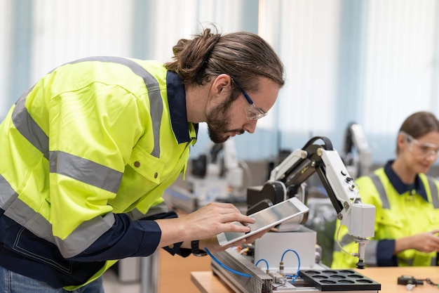 Ingegnere maschio che utilizza test remoti e controlla il modello di robot ai nella sala del laboratorio di robotica dell'accademia