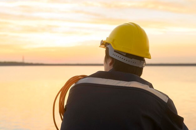 A male engineer wearing a protective helmet at sunsetx9