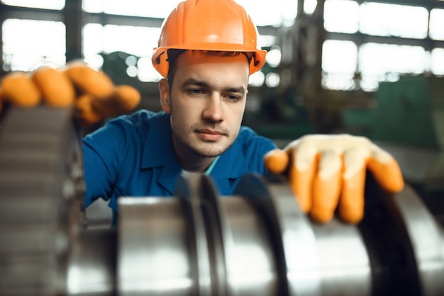 Foto l'ingegnere maschio lavora con la turbina in fabbrica. produzione industriale, ingegneria della lavorazione dei metalli, produzione di macchine elettriche