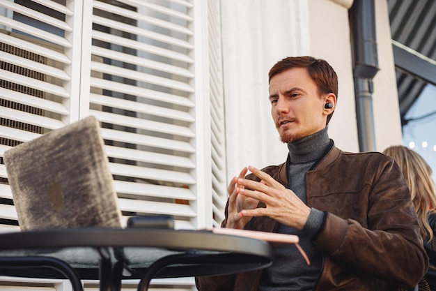 male entrepreneur talking during online meeting via laptop while working