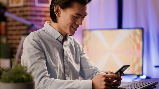 Male entrepreneur using smartphone on break to text messages and scroll social media website app. Browsing internet network on mobile phone with touchscreen, remote business job.