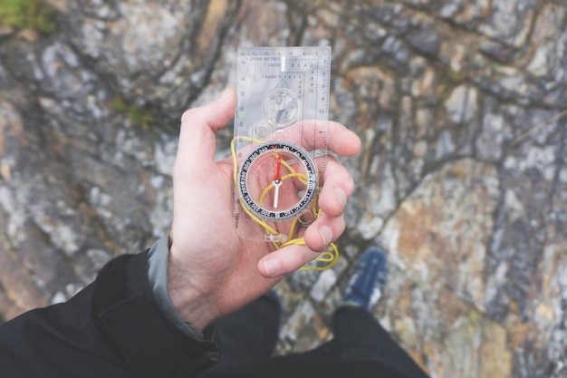 Male explorer with a compass in her hand Point of view