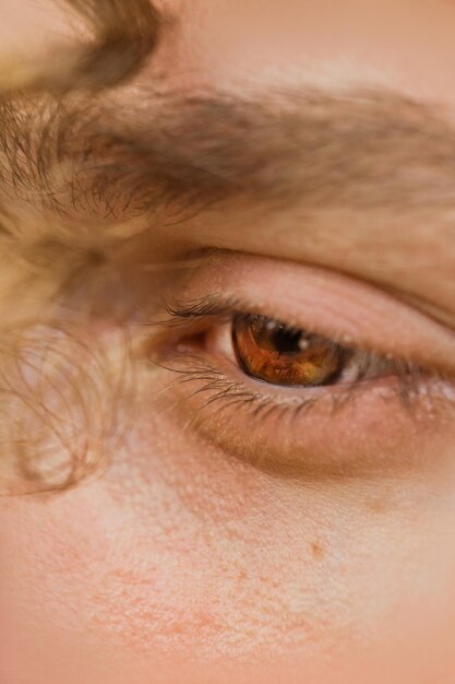 Male eye close up a curl of curly hair hangs over a man's face thoughtful look into the void